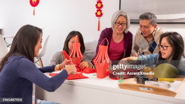 family makes new years lanterns together - 20 24 years asian stock pictures, royalty-free photos & images