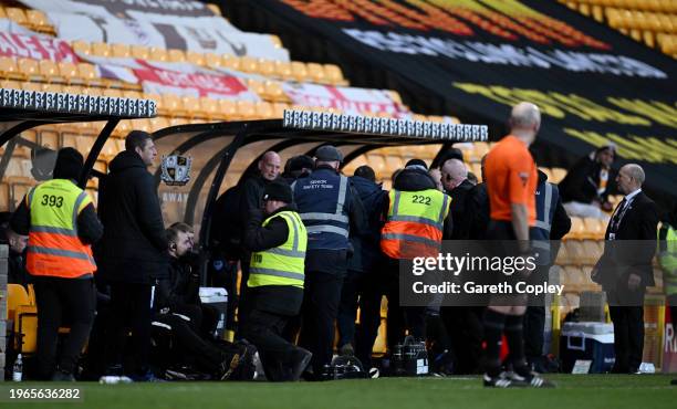 Ground stewards remove a fan who invaded the field to confront referee Craig Hicks during the Sky Bet League One match between Port Vale and...