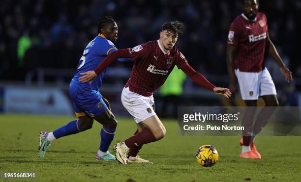 Kieron Bowie of Northampton Town moves forward with the ball away from Tunmise Sobowale of Shrewsbury Town during the Sky Bet League One match...