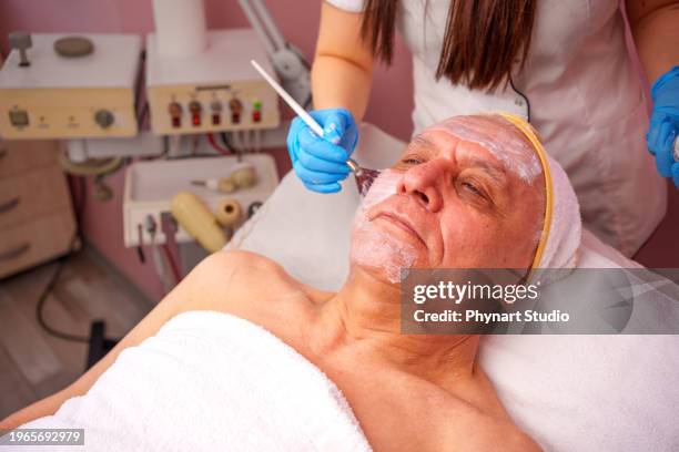 senior adult man in a spa for beauty treatments. - schoonheidsspecialist natuur stockfoto's en -beelden