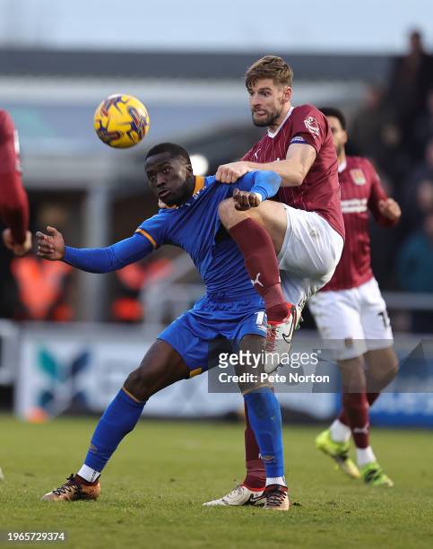 Jon Guthrie of Northampton Town contests the ball with Dan Udoh of Shrewsbury Town during the Sky Bet League One match between Northampton Town and...