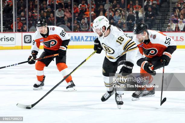Pavel Zacha of the Boston Bruins skates with the puck past Cam Atkinson and Rasmus Ristolainen of the Philadelphia Flyers during the third period at...