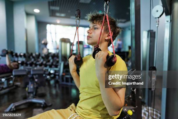 ragazzo adolescente che si esercita in una palestra - macchina per allenamento foto e immagini stock