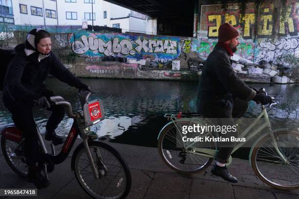 Bike riders commute along the Regent's Canal in the early morning winter sun on the 26th of January 2024, London, United Kingdom. One of the riders...