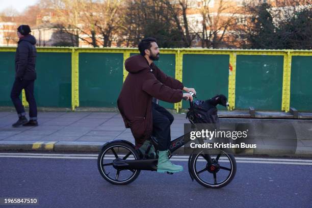 Bike rider commutes with his dog in Hackney, East London in the early morning winter sun on the 26th of January 2024, London, United Kingdom.