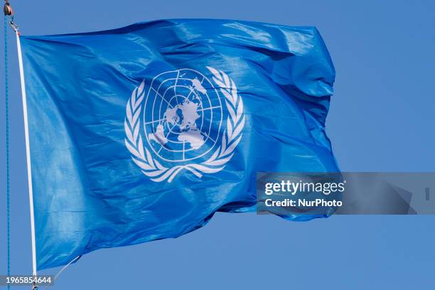 Flag of the United Nations wave in the wind on a flagpole located in the courtyard of the ICJ. The flag is a sky blue banner containing the United...