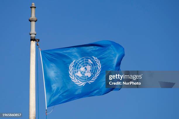 Flag of the United Nations wave in the wind on a flagpole located in the courtyard of the ICJ. The flag is a sky blue banner containing the United...