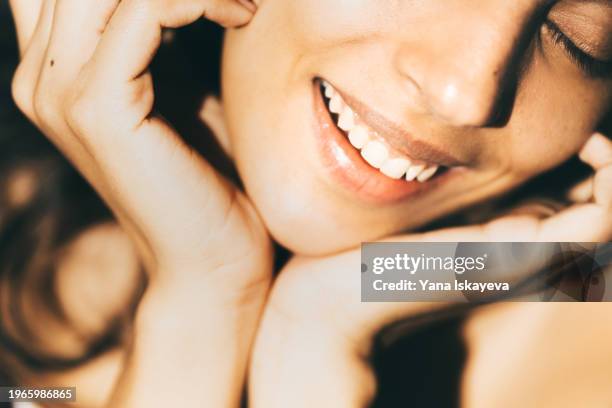 a beautiful asian woman enjoying a morning skincare routine, applying a sunblocking moisturizer to her skin - collagens stock pictures, royalty-free photos & images