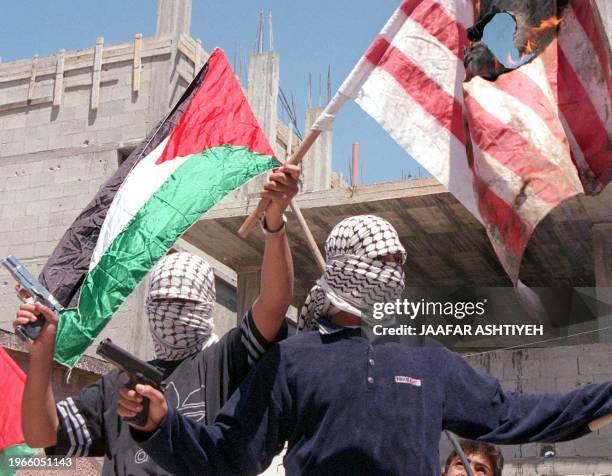 Palestinian fighters, members of Palestinian President Yasser Arafat Fatah group, burn an American flag during a May day demonstration 01 May in the...