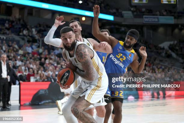 Real Madrid's French center Vincent Poirier vies with Maccabi's US center Josh Nebo during the Euroleague round 24 basketball match between Real...