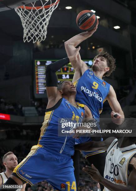 Maccabi's Israelian forward Roman Sorkin attemps a basket next to Maccabi's Cuban forward Jasiel Rivero during the Euroleague round 24 basketball...