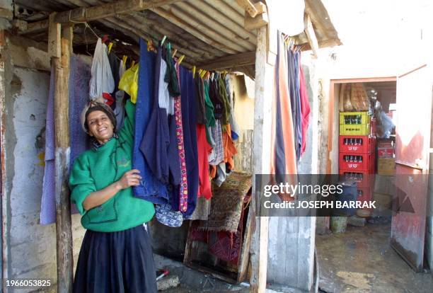 Palestinian woman hangs laundry to dry at her home 03 January 2001 in the Palestinian refugee camp of Ain al-Helweh, east of the southern port city...