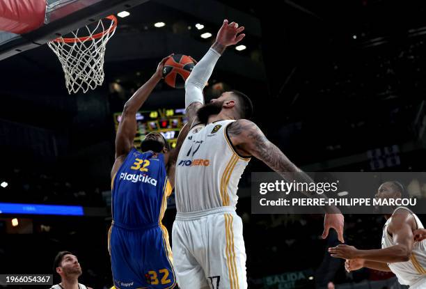 Maccabi's US center Josh Nebo attempts a basket next to Real Madrid's French center Vincent Poirier during the Euroleague round 24 basketball match...