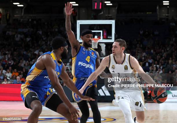 Real Madrid's French forward Fabien Causeur vies with Maccabi's US center Josh Nebo and Maccabi's US guard Lorenzo Brown during the Euroleague round...