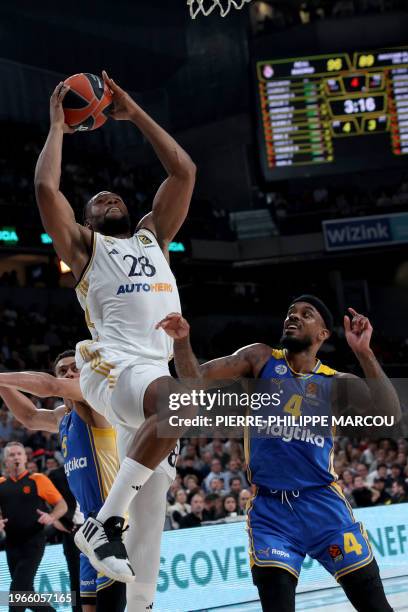 Real Madrid's French forward Guerschon Yabusele attemps a basket next to Maccabi's US guard Lorenzo Brown during the Euroleague round 24 basketball...