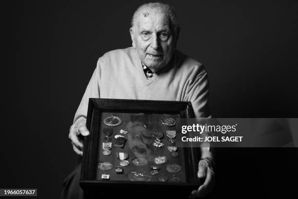 Olympic champion in Men's Team Pursuit in track cycling at the 1948 London Games, Charles Coste, poses with its table of medals during a photo...