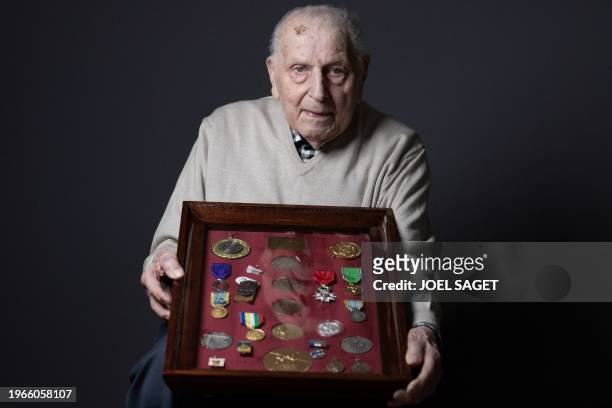 Olympic champion in Men's Team Pursuit in track cycling at the 1948 London Games, Charles Coste, poses with its table of medals during a photo...