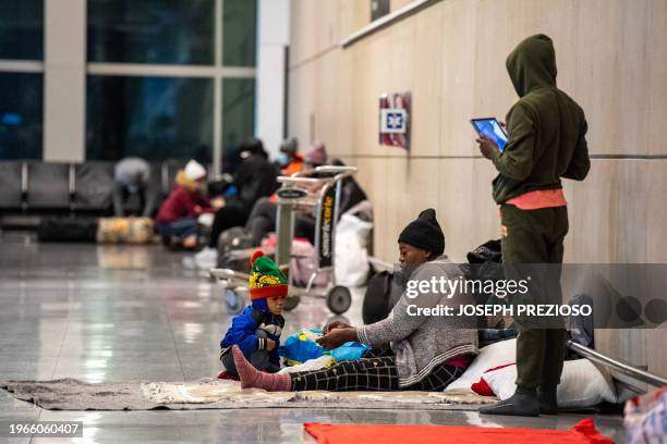 Migrants families use Terminal E at Boston Logan International Airport as a shelter on January 30 in Boston, Massachusetts. State officials are...