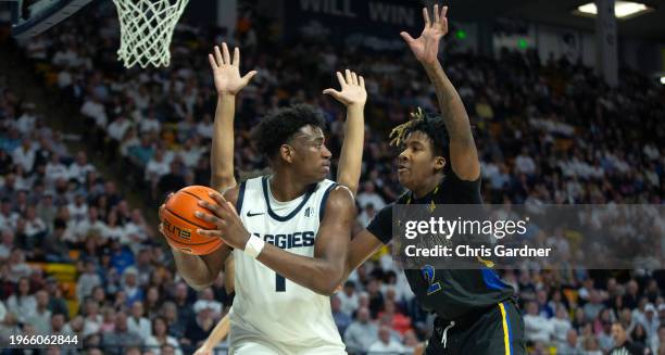 Great Osobor of the Utah State Aggies is pressured by Rickey Mitchell Jr., #2 of the San Jose State Spartans during the second half at the Dee Glen...