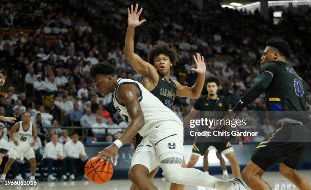 Great Osobor of the Utah State Aggies drives past Christian Wise and Myron Amey Jr., #0 of the San Jose State Spartans during the second half at the...