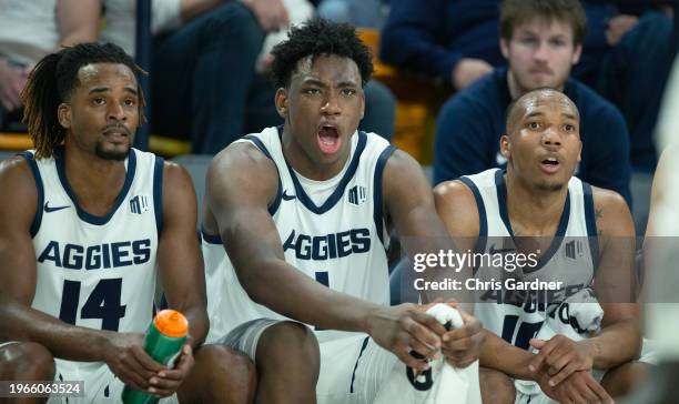 Josh Uduje, Great Osobor and Darius Brown II of the Utah State Aggies watch the final minute of the game against the San Jose State Spartans at the...