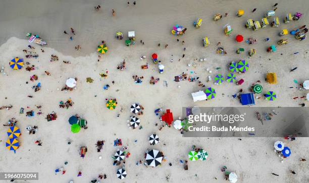 In an aerial view, people are seen enjoying the sunset at Praia do Forte on January 27, 2024 in Cabo Frio, Brazil.