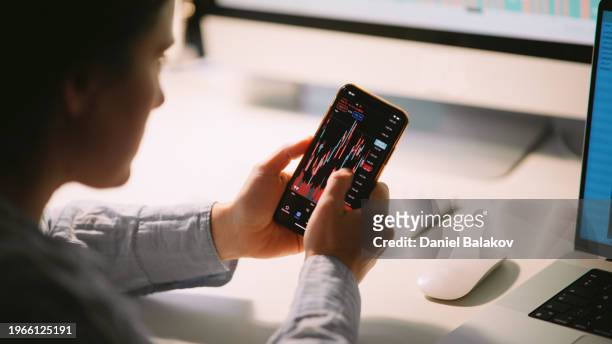 stock trader woman working at home. - bitcoin phone stock pictures, royalty-free photos & images