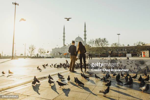people feeding pigeons in morning on eminonu square. popular tourist landmark and travel destination in turkey. - wonderlust 個照片及圖片檔