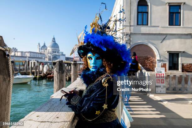 Woman is dressed for the Venice Carnival and is overlooking the Grand Canal in Venice, Italy, on January 30, 2024.