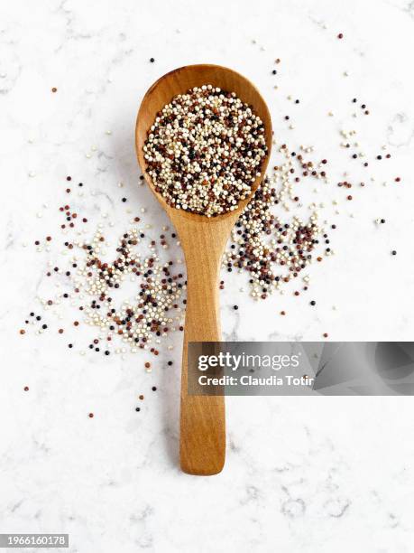 quinoa in a spoon on white background - quinoa stockfoto's en -beelden