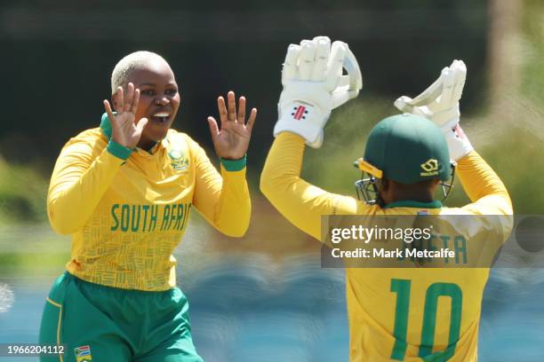 Nonkululeko Mlaba and Sinalo Jafta of South Africa celebrate taking the wicket of Tahlia McGrath of Australia during game two of the Women's T20...