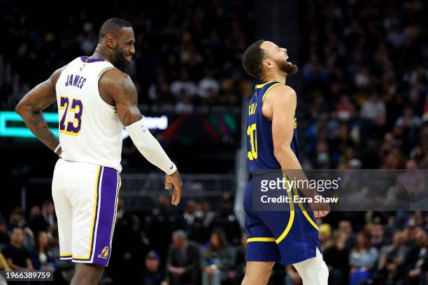 LeBron James of the Los Angeles Lakers and Stephen Curry of the Golden State Warriors make each other laugh during a stop in play in the first half...