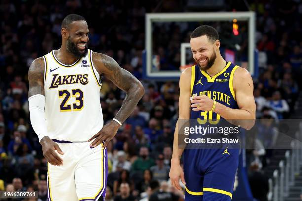 LeBron James of the Los Angeles Lakers and Stephen Curry of the Golden State Warriors make each other laugh during a stop in play in the first half...