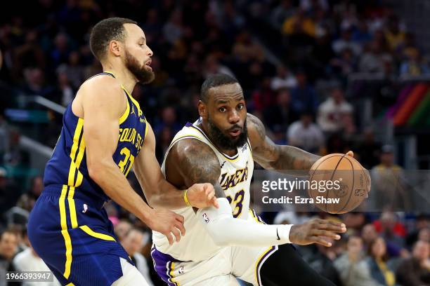 LeBron James of the Los Angeles Lakers is guarded by Stephen Curry of the Golden State Warriors in the first half at Chase Center on January 27, 2024...