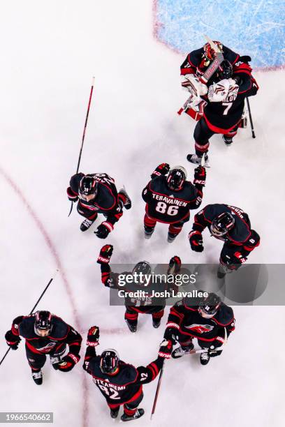 Antti Raanta of the Carolina Hurricanes celebrates with Dmitry Orlov after a 3-1 victory against the Arizona Coyotes at PNC Arena on January 27, 2024...