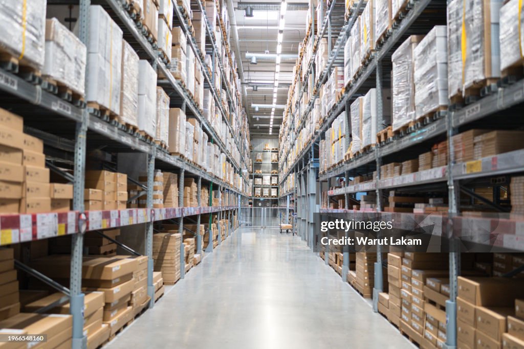 Background Distribution Warehouse With Cardboard Boxes On The Racks