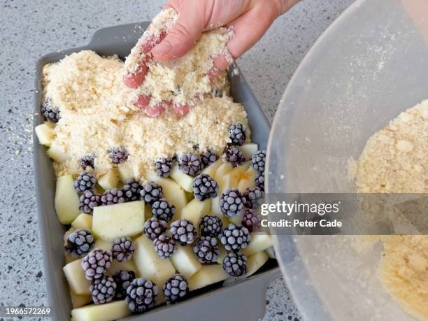 making blackberry and apple crumble in kitchen - hand fruit stock pictures, royalty-free photos & images