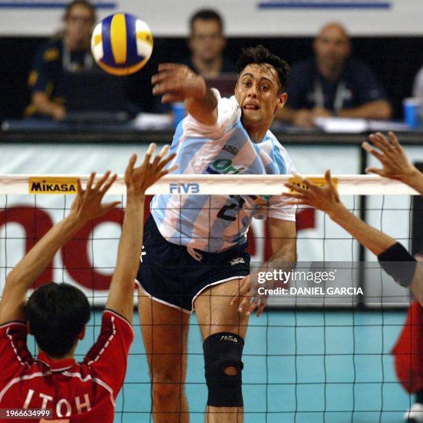 Argentinian Jorge Elgueta smashes the ball over Japanese defender Nobuhiro Ito during the Argentina-Japan Pool G-round match at the Men's Volleyball...