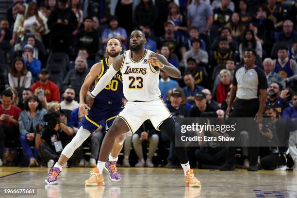 Stephen Curry of the Golden State Warriors matches up against LeBron James of the Los Angeles Lakers in overtime at Chase Center on January 27, 2024...