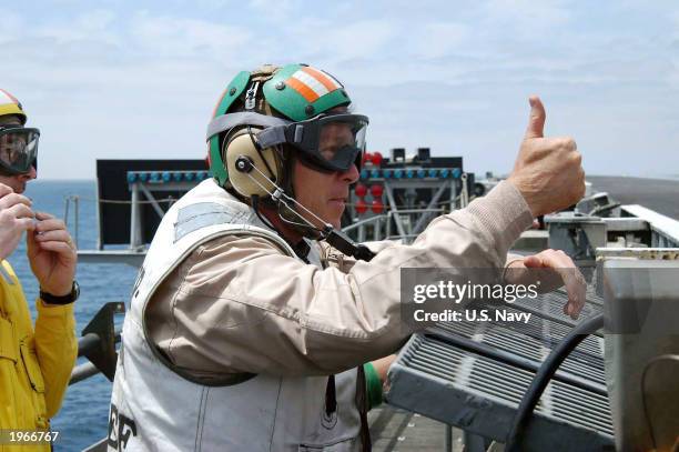 President George W. Bush gives a thumbs up before the launch of an aircraft on the flight deck of USS Abraham Lincoln May 1, 2003 at sea off the...