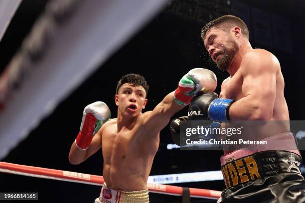 John Ryder of Great Britain takes a left from Jaime Munguia of Mexico during the WBC silver super middleweight title fight at Footprint Center on...