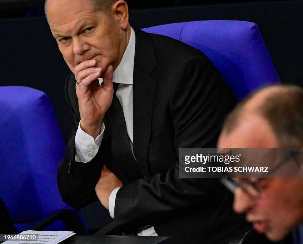 German Chancellor Olaf Scholz looks over at to Leader of Germany's Christian Democratic Union CDU Friedrich Merz speaking during a plenary session in...