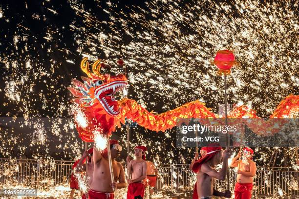 Folk artists perform dragon dance in the midst of molten iron fireworks to welcome the Spring Festival on January 26, 2024 in Chongqing, China. The...