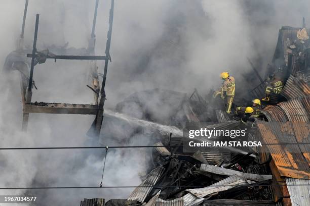 Firefighters respond as a huge fire engulfs buildings at a crowded neighborhood in Manila on January 31, 2024.