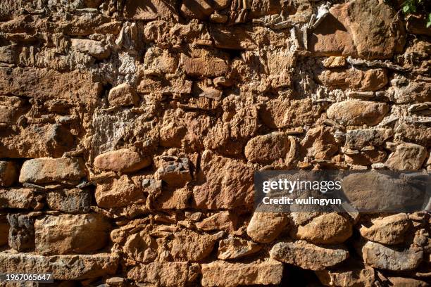 weathered rock wall of old village - crag stock pictures, royalty-free photos & images