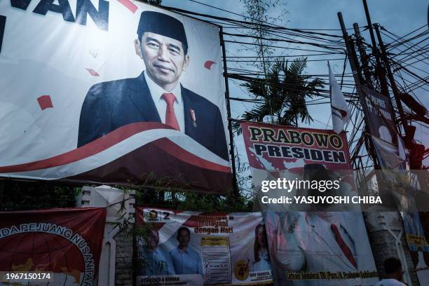 Campaign poster of presidential candidate and Indonesia's Defence Minister Prabowo Subianto and a portrait of President Joko Widodo are seen along a...