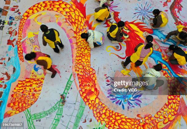 Children draw dragon-themed pictures on a canvas at a shopping center ahead of the Year of the Dragon on January 27, 2024 in Xuzhou, Jiangsu Province...