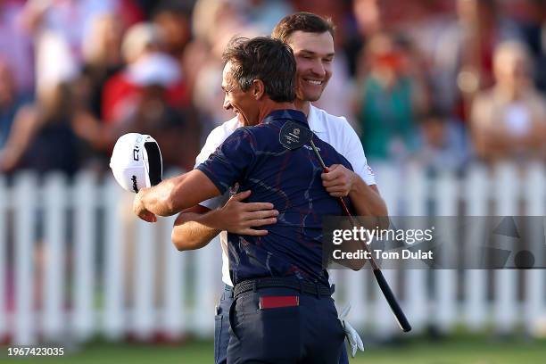 Thorbjorn Olesen of Denmark embraces Rasmus Hojgaard of Denmark as he celebrates victory on the 18th green during Day Four of the Ras Al Khaimah...