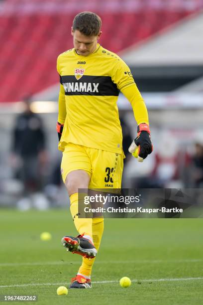 Alexander Nuebel of VfB Stuttgart kicks tennis balls of the pitch which are thrown by fans on the pitch to show their protest against the German...