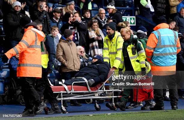 Paramedics escort a fan away from the pitch following a pitch invasion during the Emirates FA Cup Fourth Round match between West Bromwich Albion and...